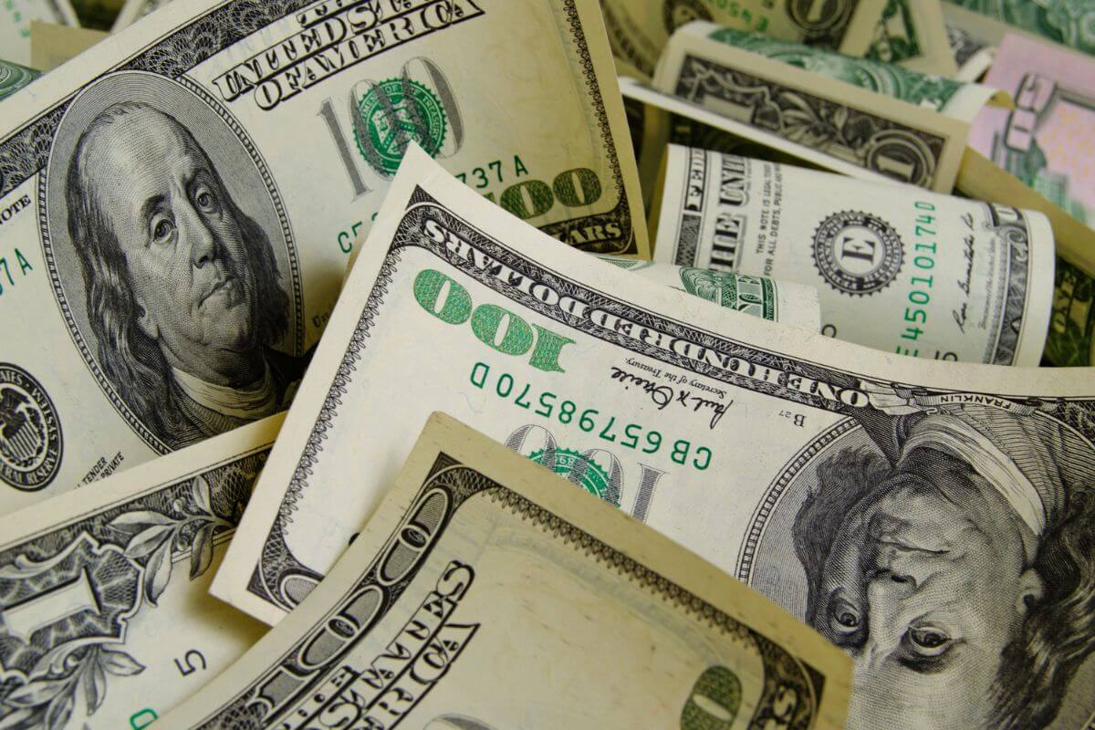 The picture shows dollar bills referring to saving 70% of your income making it easier to focus on what really matters and for long-term financial goals.