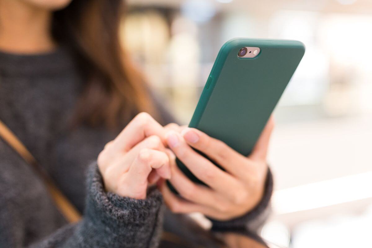 The photo shows a girl using a phone referring to refusing to upgrade your phone means more cash for investments and fewer unnecessary expenses.