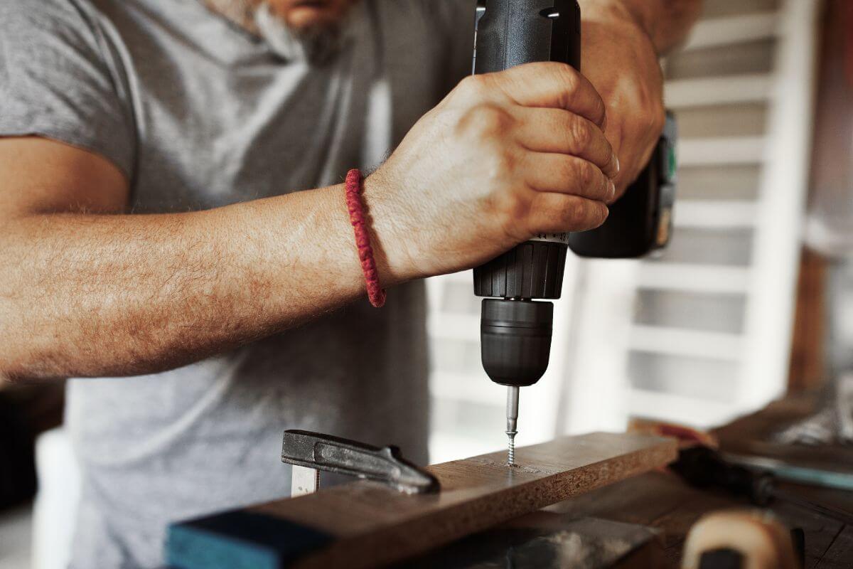 The picture of a man using a tool to grind the metal which means to get really into DIY to avoid paying for repairs to grow your savings and taking control of your money goes.