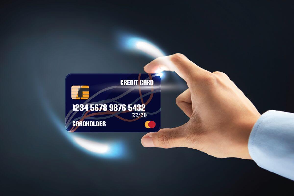 The photo tells about a man's hand holding a card indicating to freeze your credit cards in a block of ice to help you avoid impulse buying and stay on track.