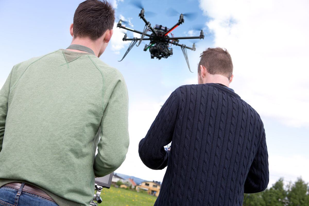 The picture tells about two men operating the drone refers to a drone photographer specializing in real estate or weddings pays well and lets you work creatively.