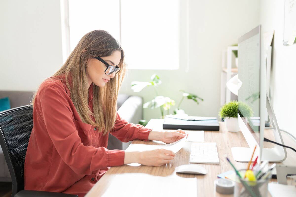 The picture of a computer on the table, pens, plants, and a girl reading the paper indicates to subtitler or captioner for films which is a remote job with flexible hours and good pay.