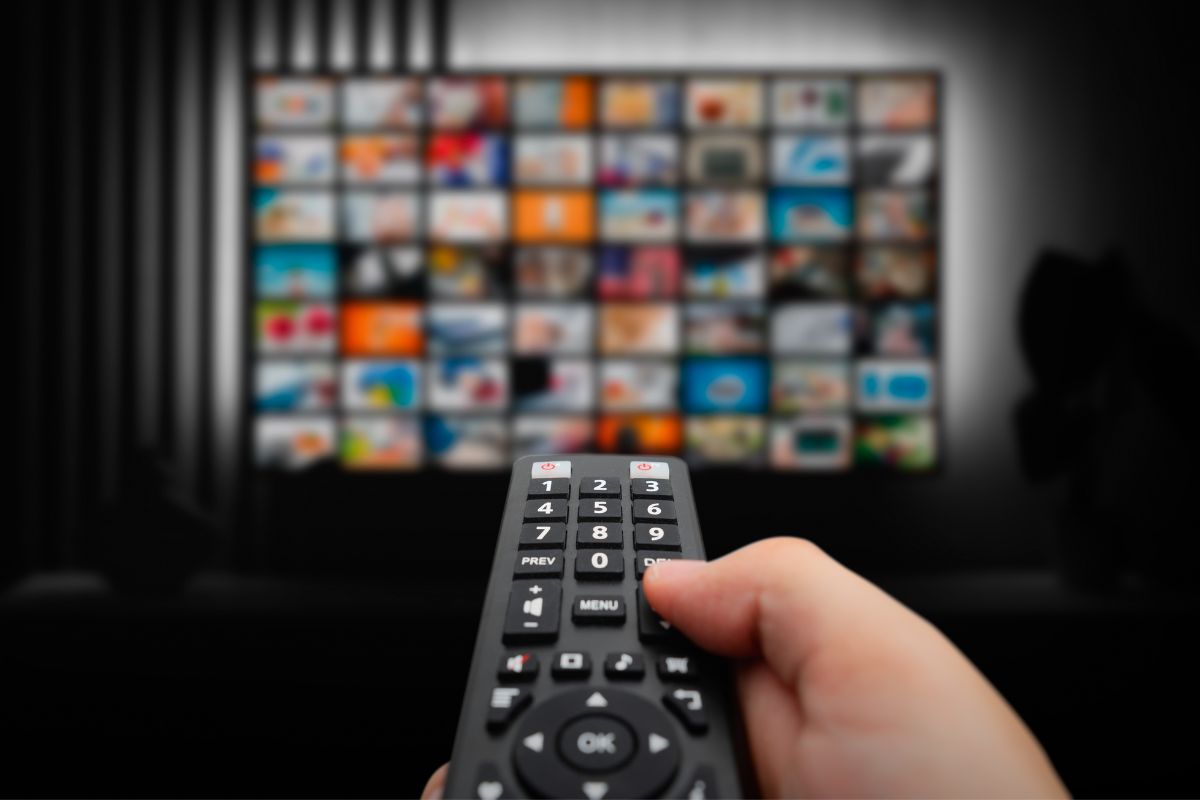 Photo shows a man watching a TV.