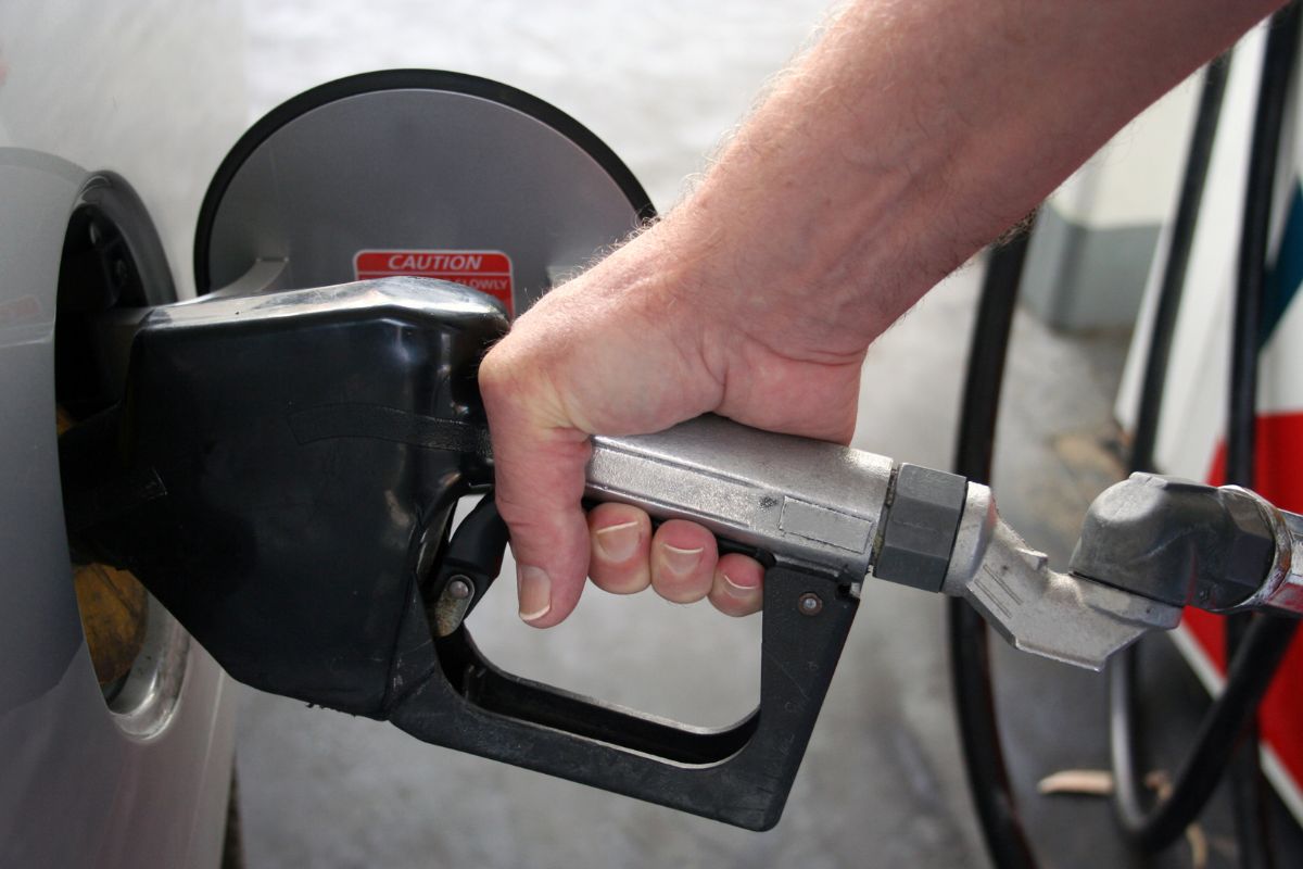 Picture of a man's hand refilling gas in his car.