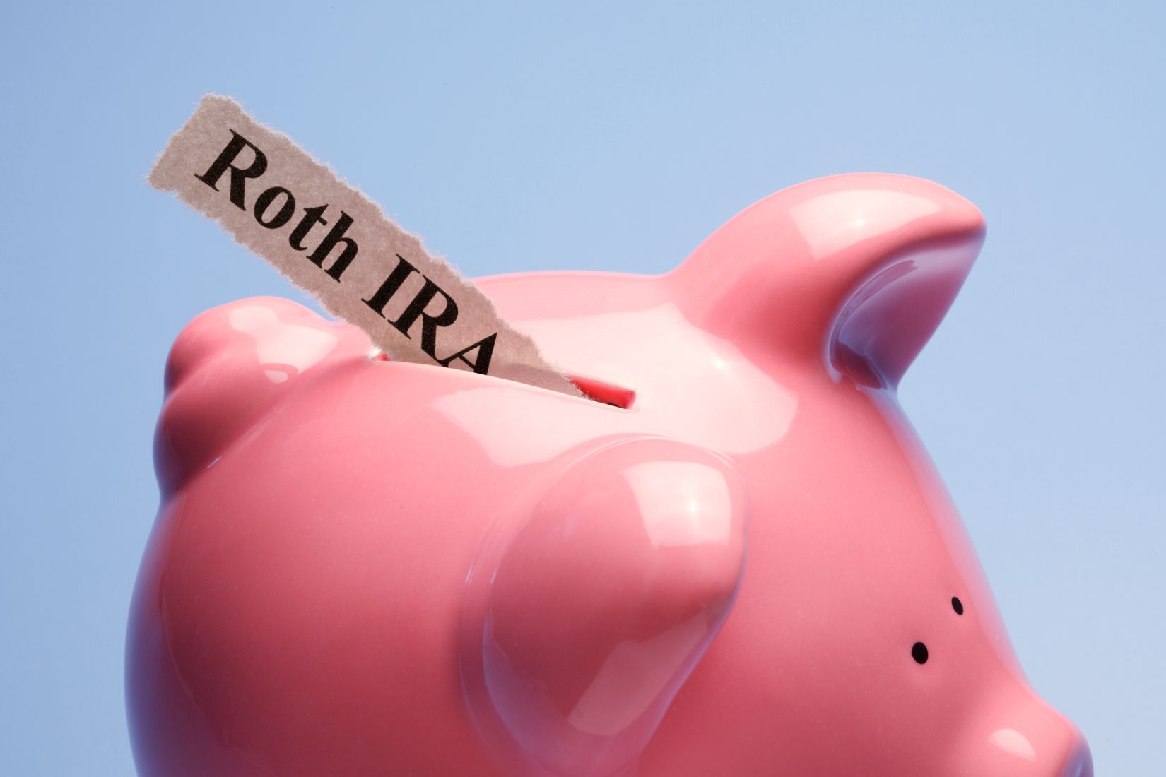Picture of a piggy bank with Roth IRA wording on paper.