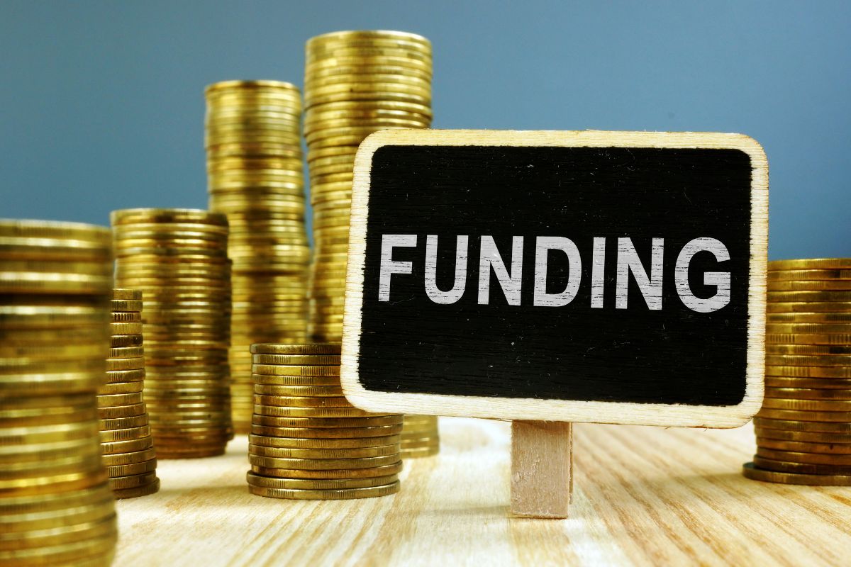 Image of coins and a blackboard with funding written.