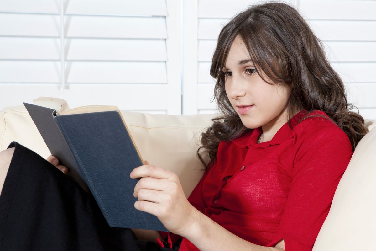 Photo of a young lady reading a book.