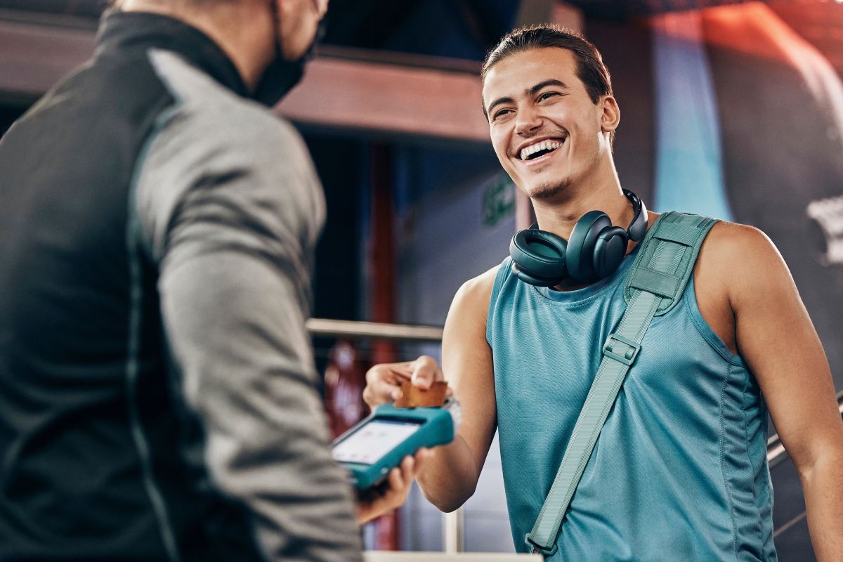 Picture of a man paying for a gym membership.