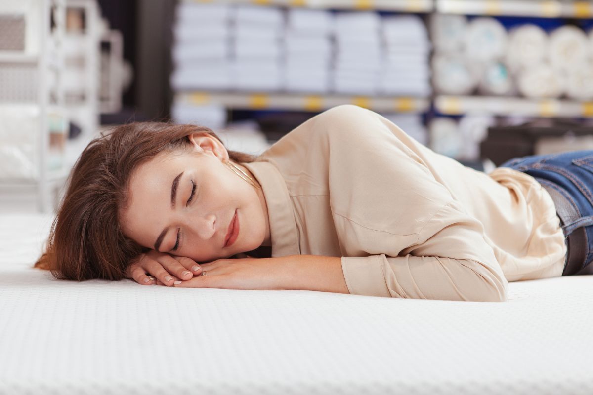 The photo shows a woman sleeping on a mattress.