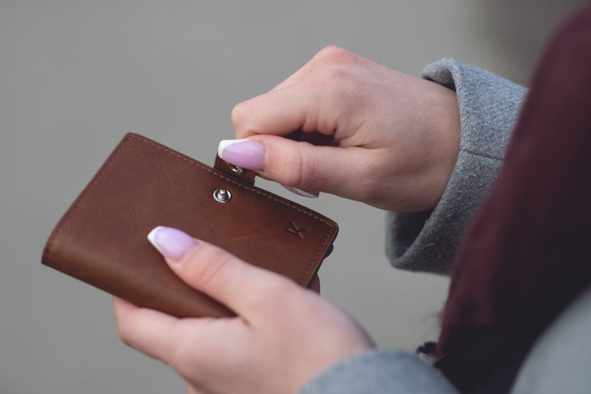 The picture of a woman closing her wallet.