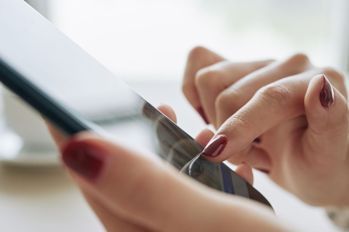 The image shows a woman's hand using an app.
