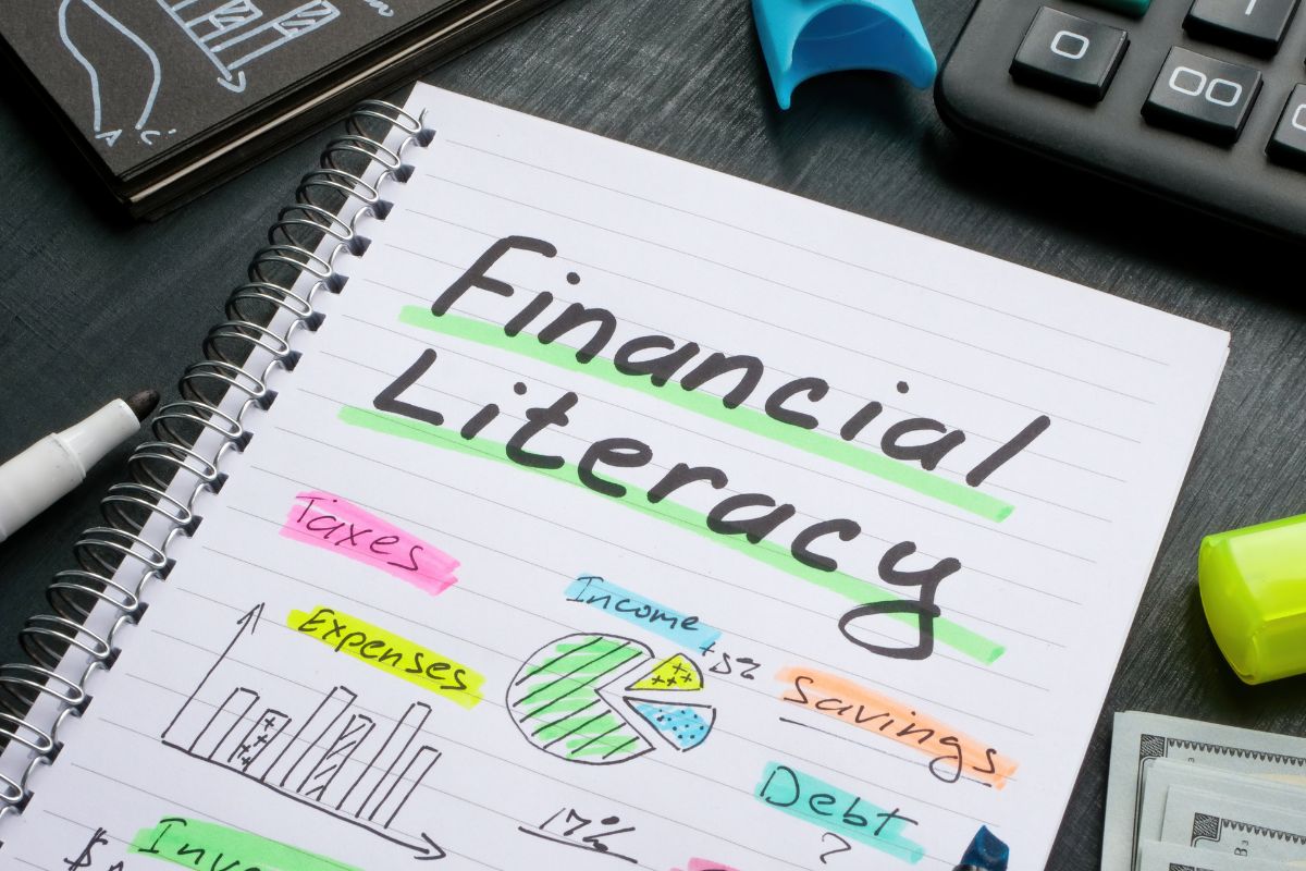 The photo shows a notebook with financial literacy written.