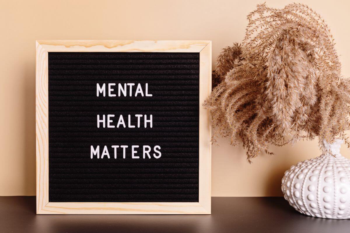The image tells about a decoration and a blackboard with notes referring to watching your mental health can help you stay focused and motivated as you work through financial challenges.