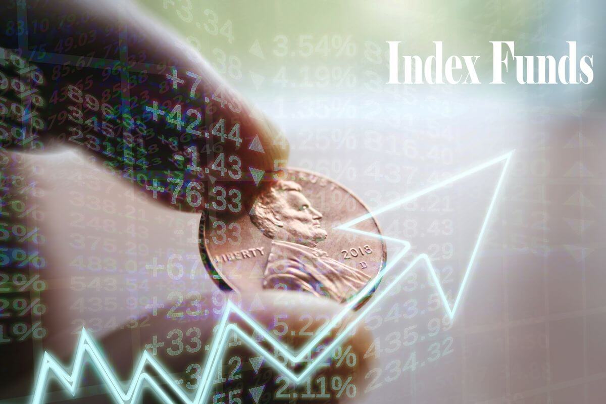 The photo tells about a man's hand holding a coin and a virtual arrow on the screen, numbers, and notes which means investing in low-cost index funds regularly helps your money grow with the market.