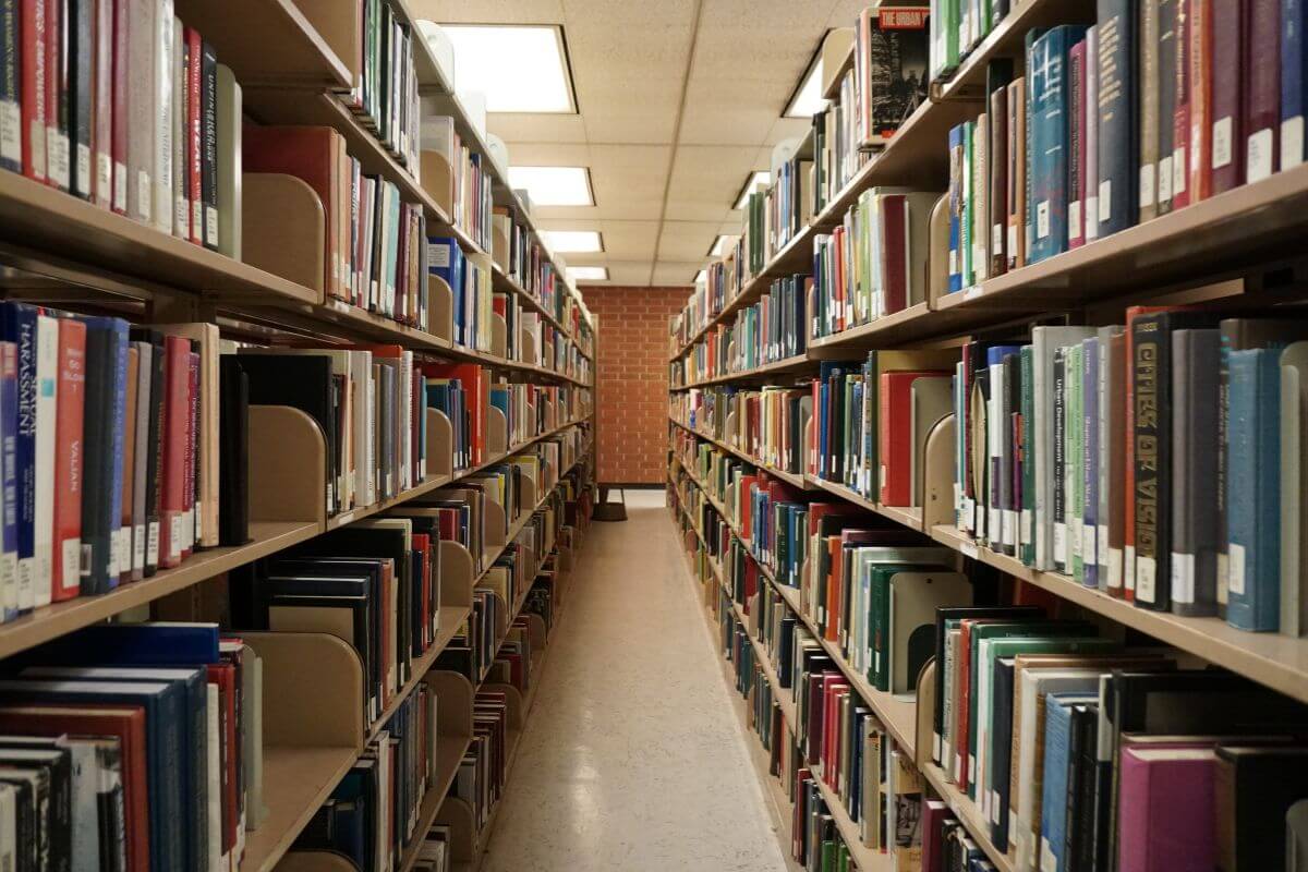The photo shows books on the shelves in the spacious room referring to finding free entertainment and education is an easy way to save money while still having fun or learning new things.