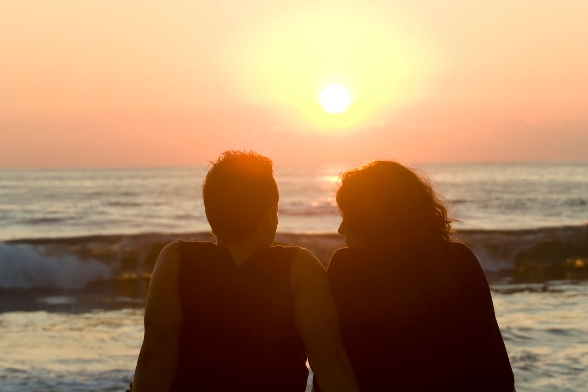 Photo of a couple watching the sunset.