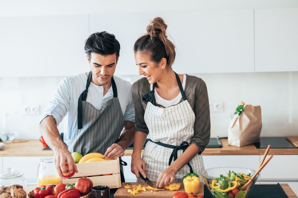 The image of a couple cooking at home.