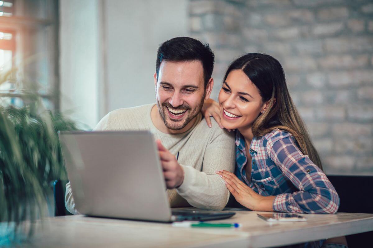 The photo tells about a couple using a laptop to take free dance online, it's a unique way to connect without spending a penny. 