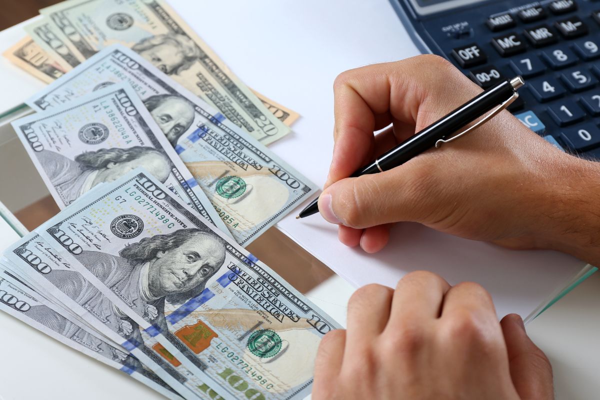 The photo shows a man's hand assigning every dollar.