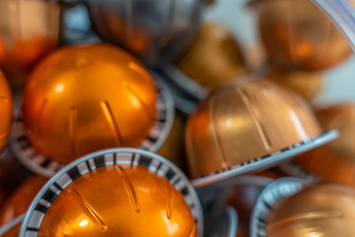 The photo shows single-serve coffee pods in a golden container that cost way more per serving than regular coffee, a ground coffee lasts longer and costs less.