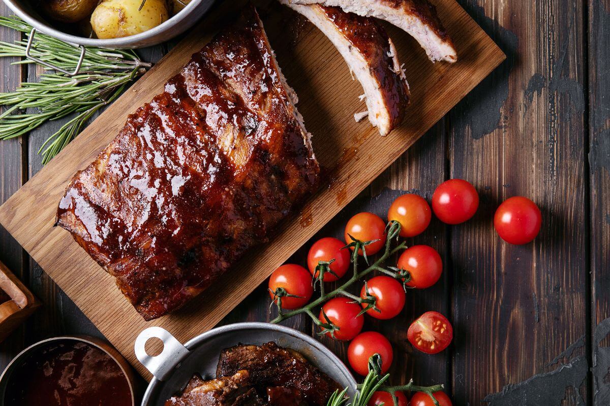 The image shows tomatoes, bowls with meals, and a wooden board with cooked meat sliced which means a homemade meal of their favorite dish is a simple but thoughtful way to show love.
