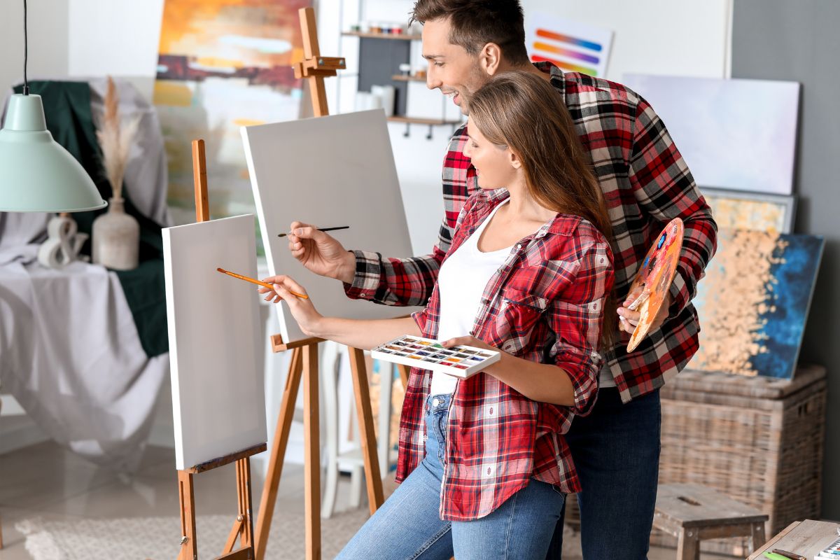 The image of a couple painting together.
