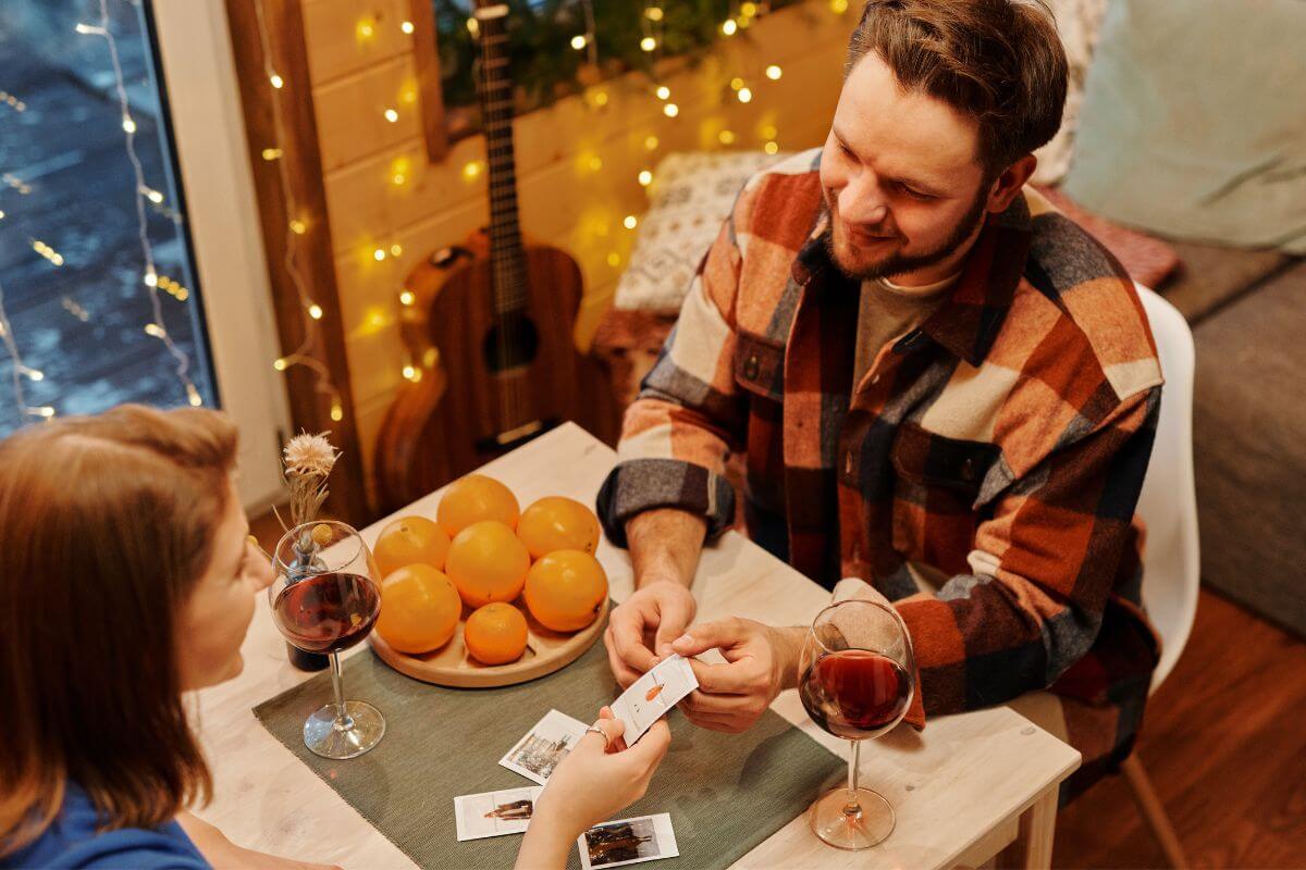 The image shows drinks on the table, a plate with orange fruit, and a couple playing cards with personal messages or photos, a small gift still feels special and thoughtful.