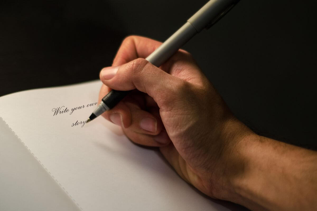 The image shows a man's hand and writing on the paper which means creating a short story featuring them as the main character is a creative way to show love.