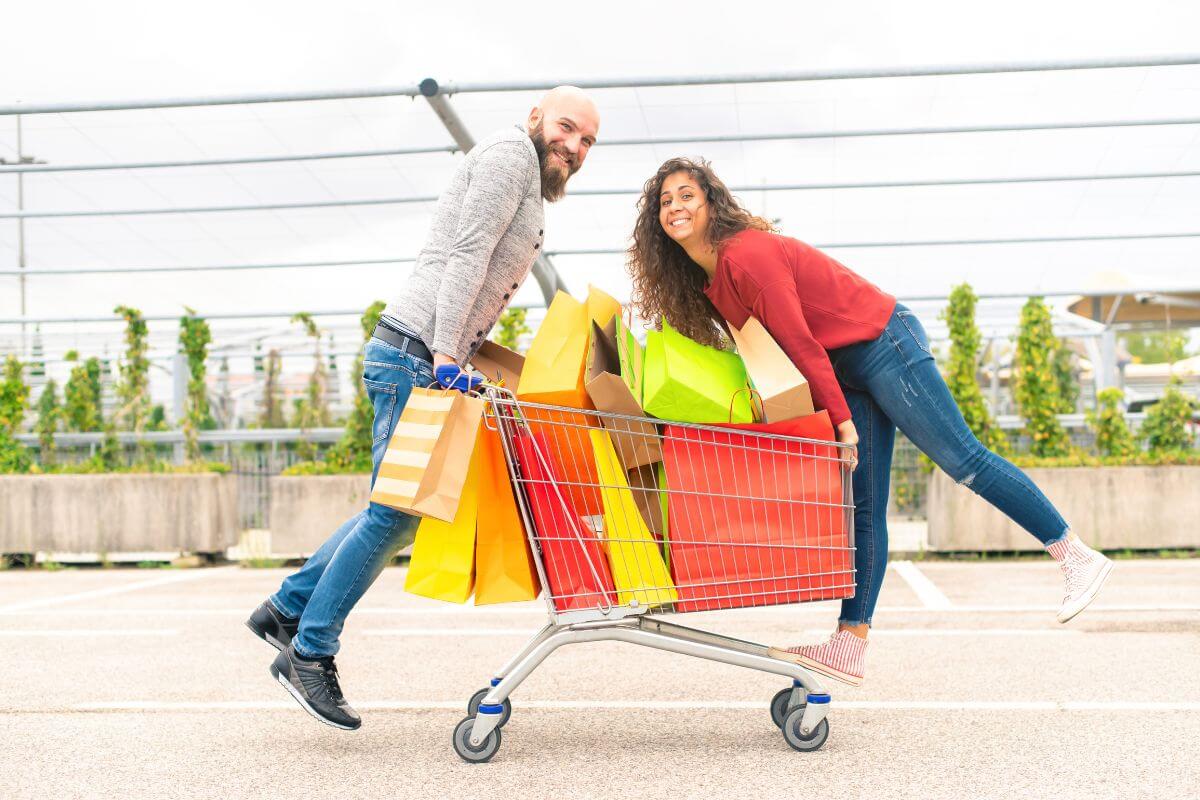 The picture is about a cart with shopping bags and a couple referring to spending irresponsibly without considering future consequences and struggling to build financial security.