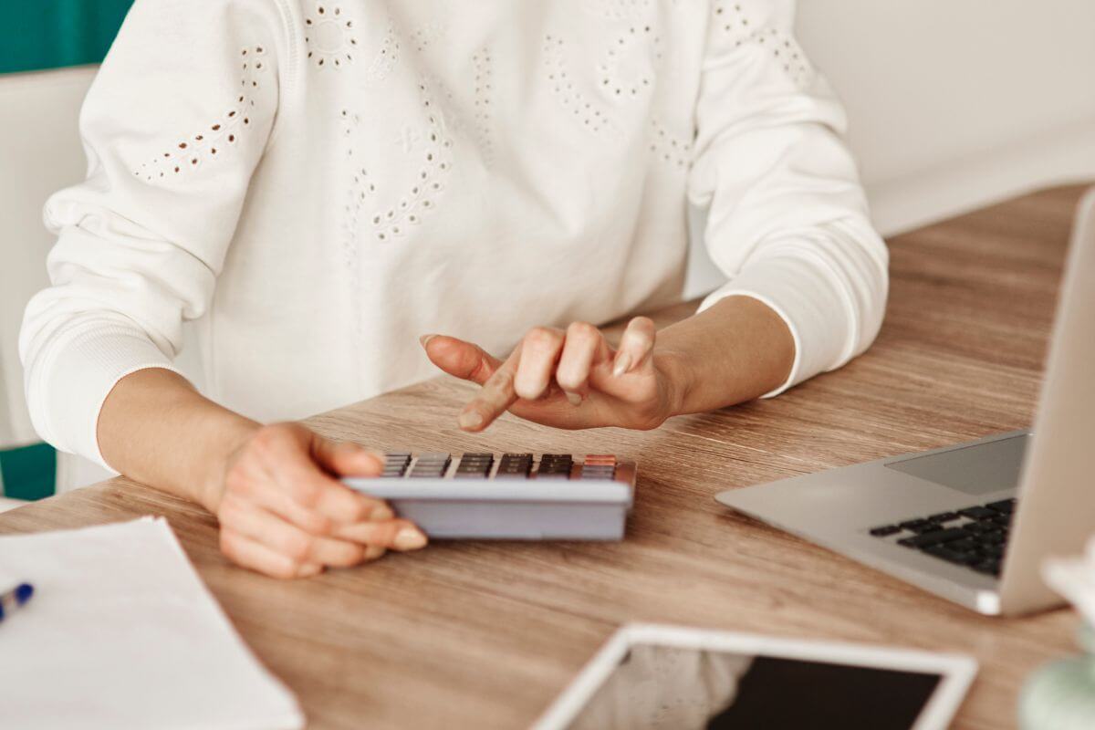 The picture shows a laptop, a tablet, and a girl's hand calculating indicating that dismisses the importance of budgeting and may struggle to manage money wisely.