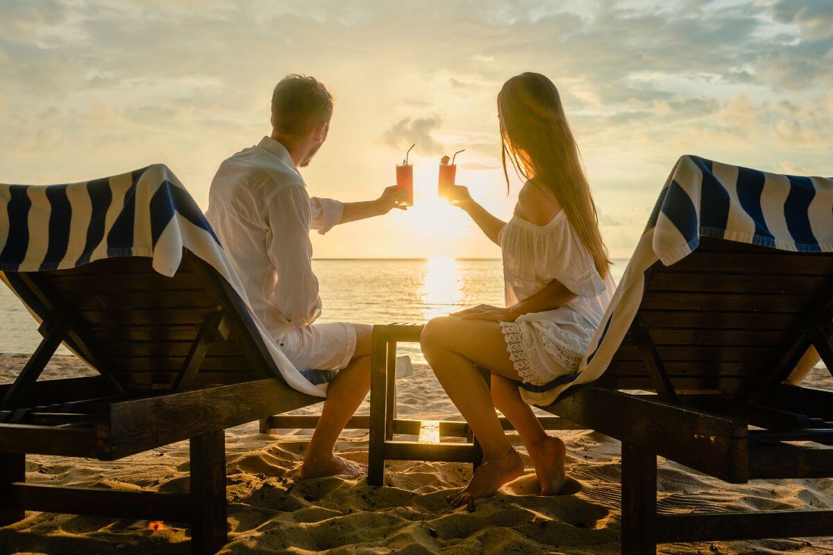 The photo tells about a couple having a drink beside the sea while watching sunset which means to finance their lifestyle without reciprocation can create stress.