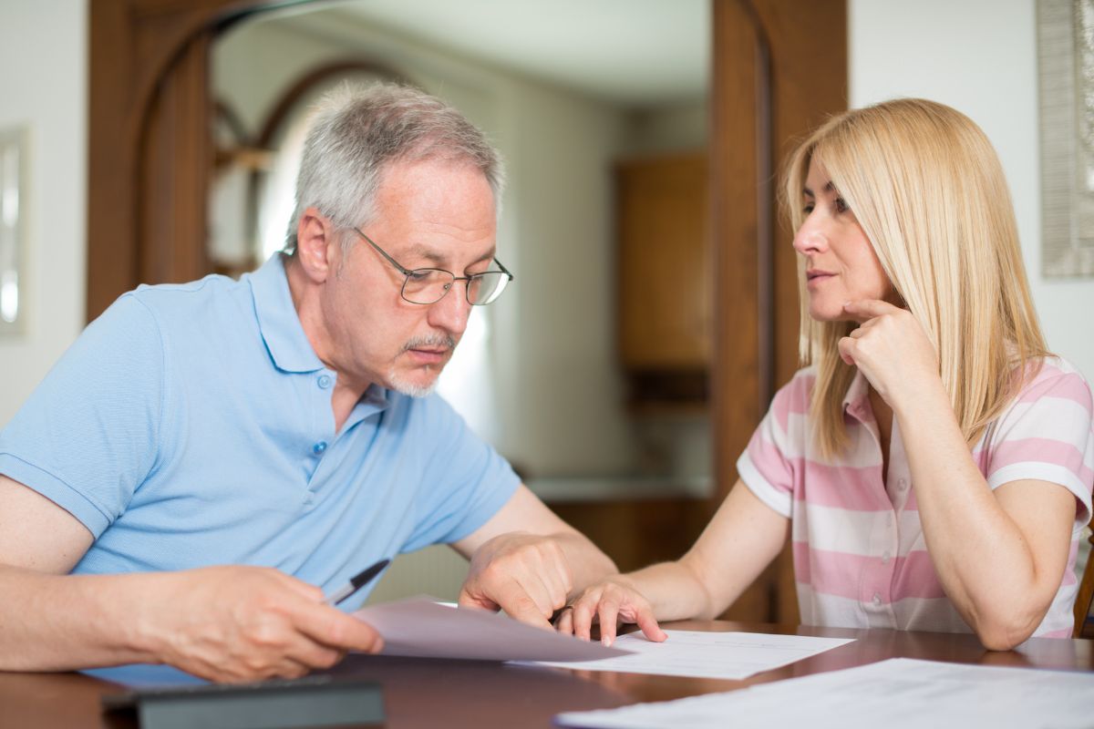 Picture shows couple calculating their monthly expenses.