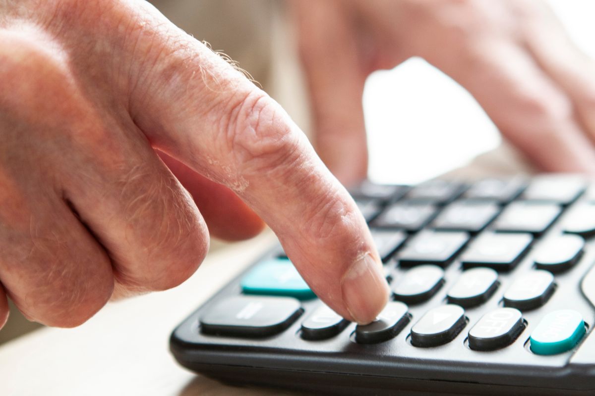 The picture shows a senior man calculating.