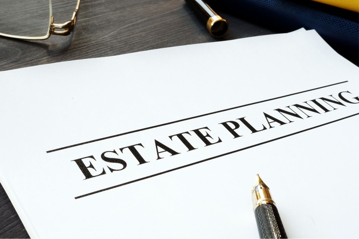 The image shows a pen and paper with estate planning wording.
