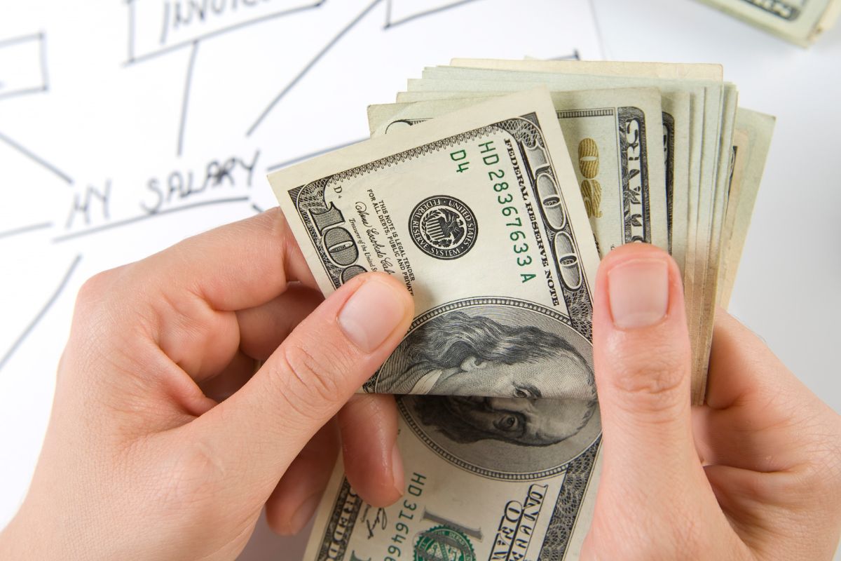An image of a woman's hand counting her salary.