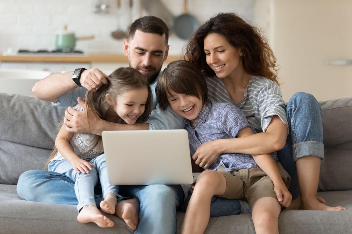 The image shows a group of families watching over the laptop referring to the focus on experiences over material possessions making it easier to keep spending under control.
