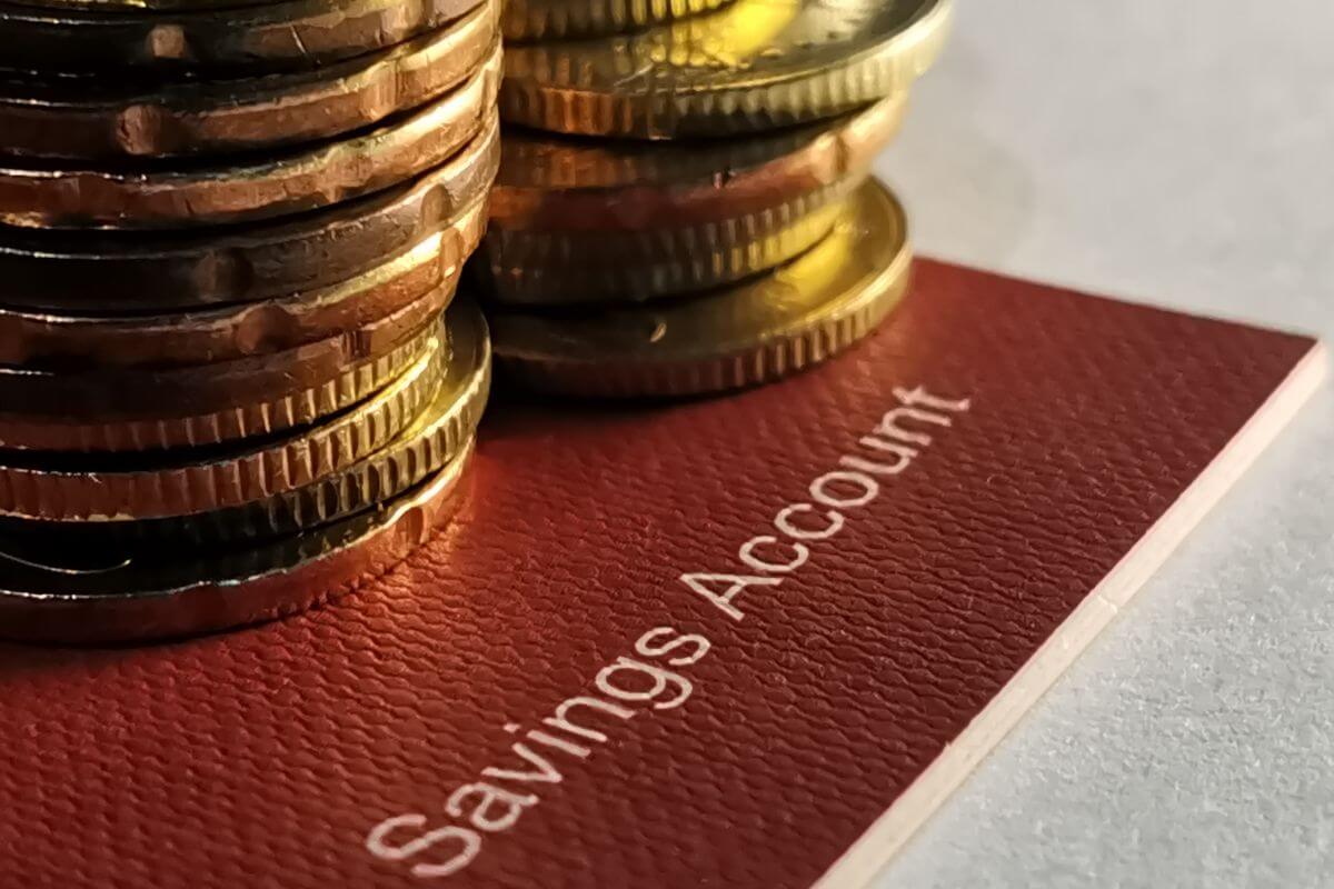 The picture tells about stock coins and a bank book with notes which means that redirecting saved money into savings can lead to long-term stability and security.