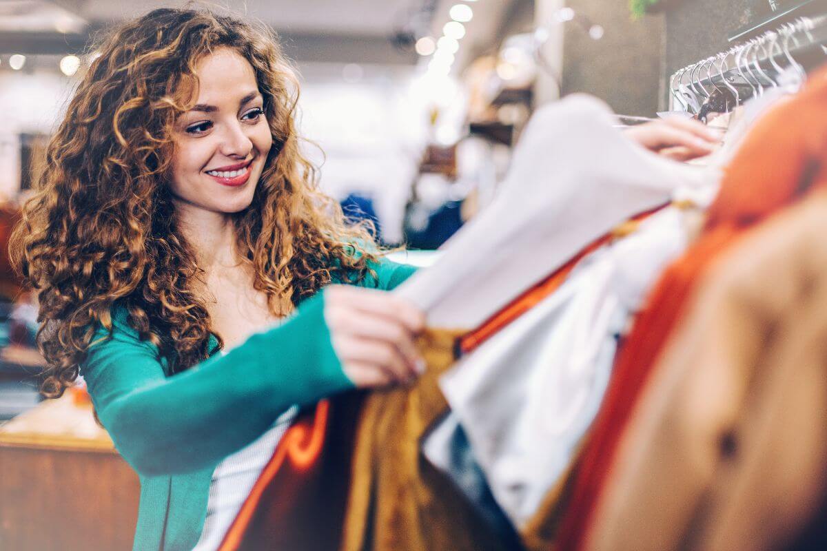 The picture tells about a girl picking up clothes indicating that avoiding non-essential spending for the entire year helps cut out unnecessary purchases and build better habits.