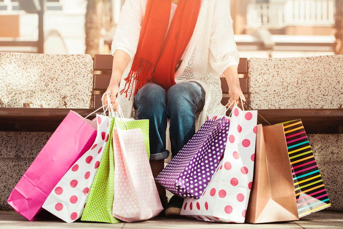 The photo tells about a girl sitting on the bench while carrying shopping bags indicating that this challenge helps break impulsive shopping habits and save money which is a step toward financial freedom and smarter choices.