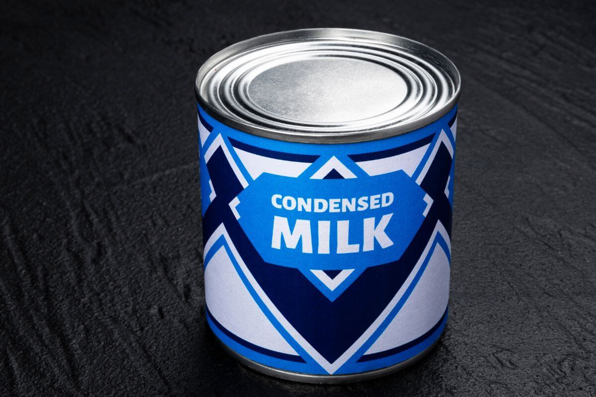 The picture shows a canned condensed milk on the table referring to a great for making homemade desserts on a budget.