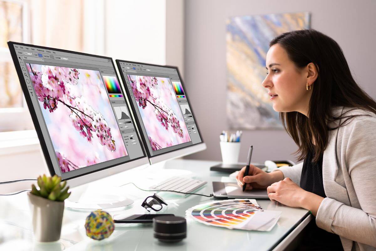 The photo shows color reference on the table, a plant, and a girl designing the object on the monitor which means a graphic design can be a great way to make money from home.