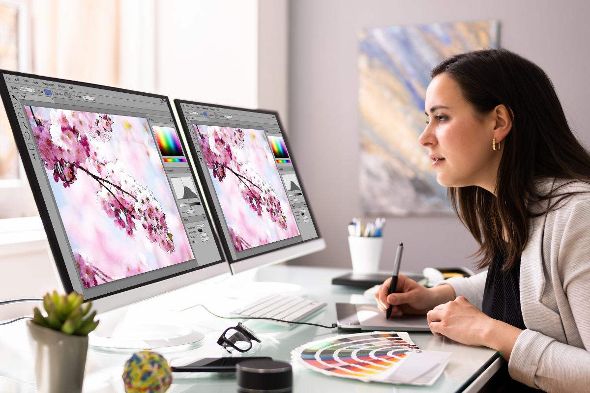 The picture shows a woman working as a graphic designer.