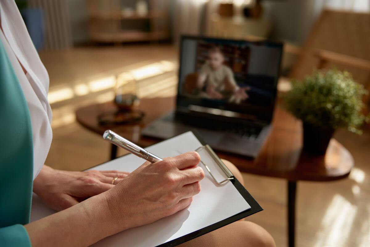 The picture of a girl taking down notes of what her client telling her online which means online consulting through email is a great way to work from home while sharing knowledge.