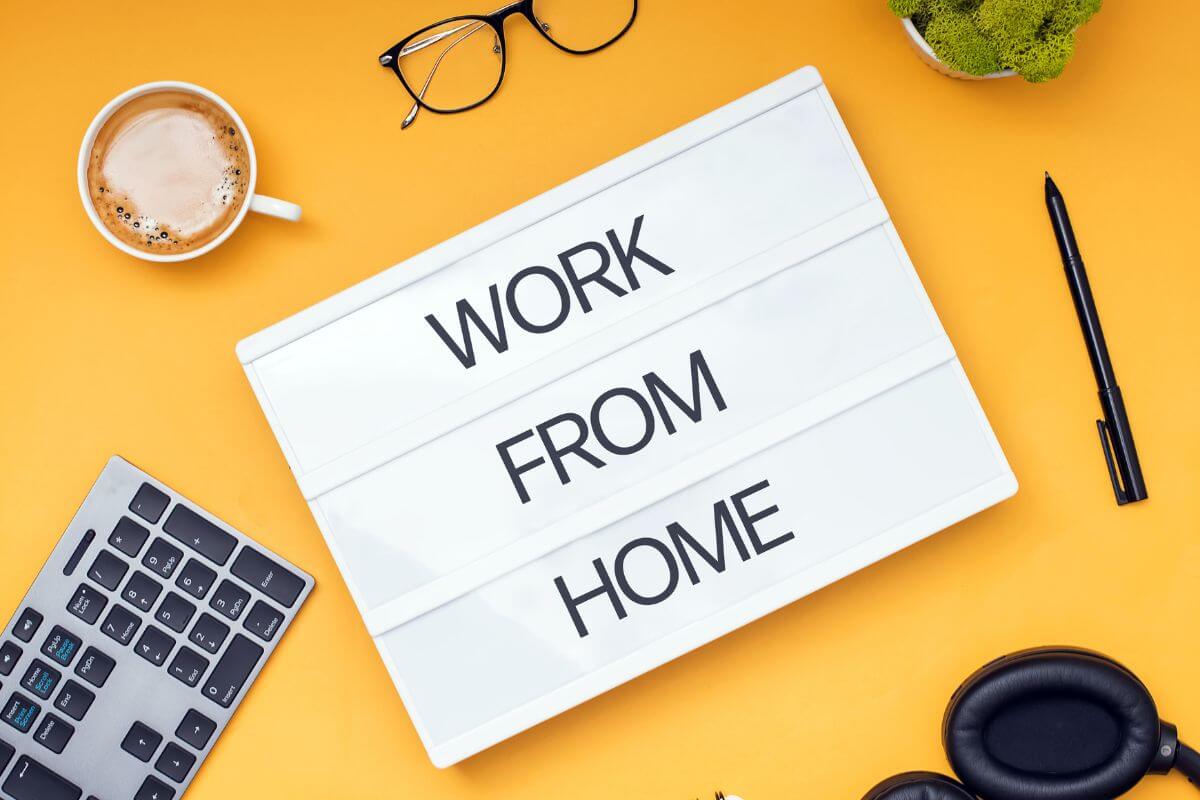 The picture tells about a keyboard, a coffee, an eyeglass, a plant, a pen, a headphone, and a white paper with notes referring to finding more work-from-home jobs that can build a career on your own terms.
