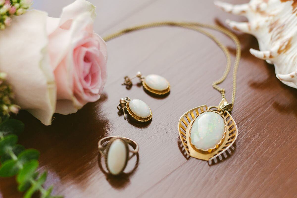 The image shows a rose, a shell, and a set of pearl jewelry indicating that thrift a unique gift, is an easy way to be romantic without overspending.