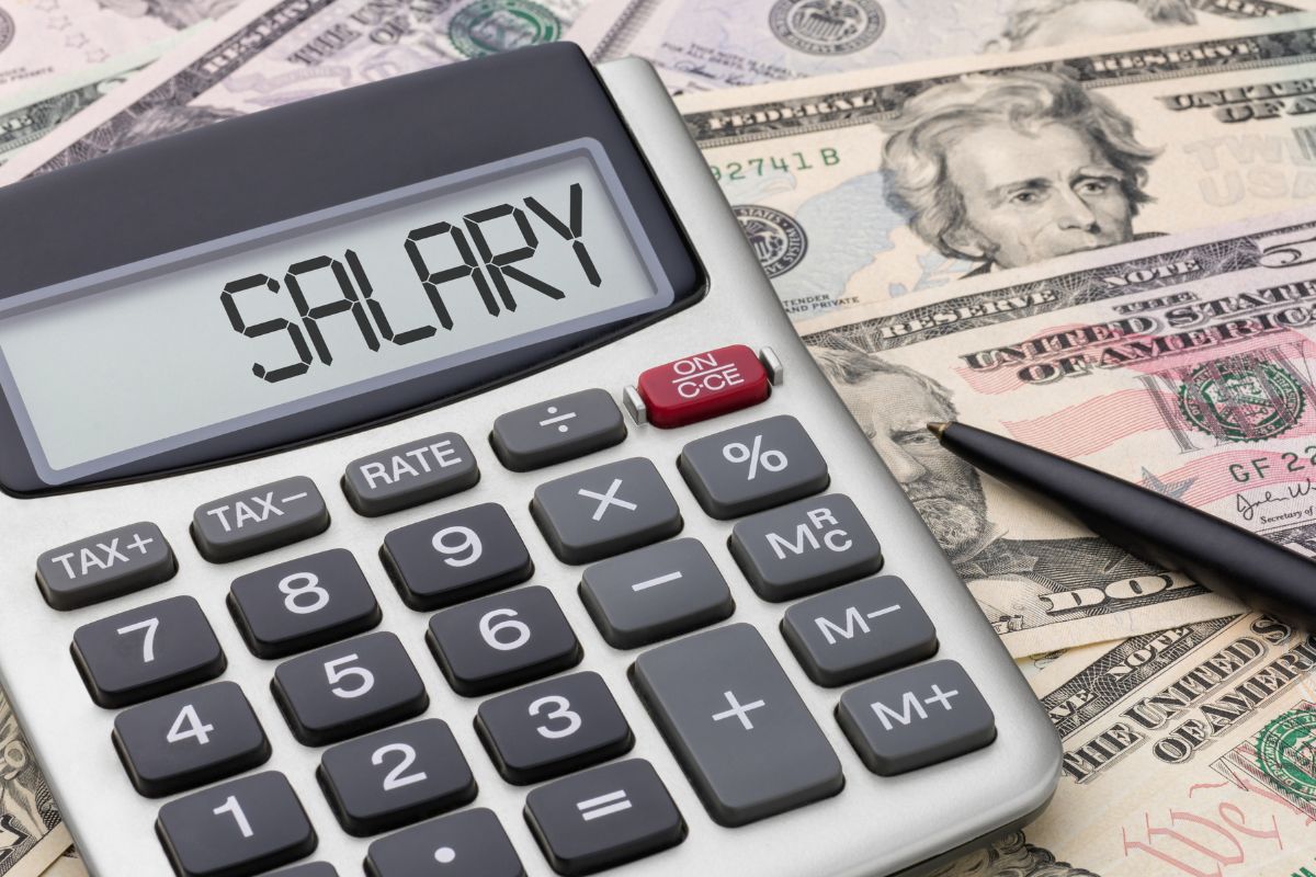 Image shows money and a calculator with salary wording.