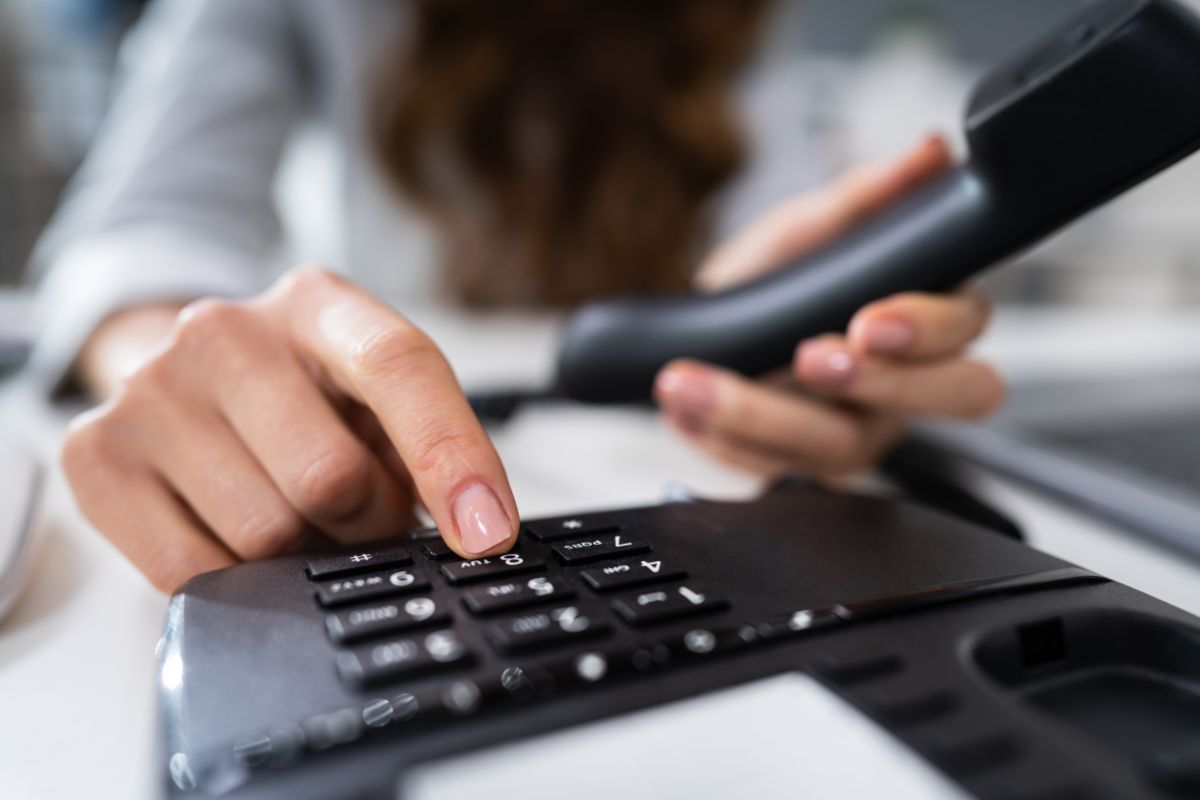 Picture of a woman using a landline phone.