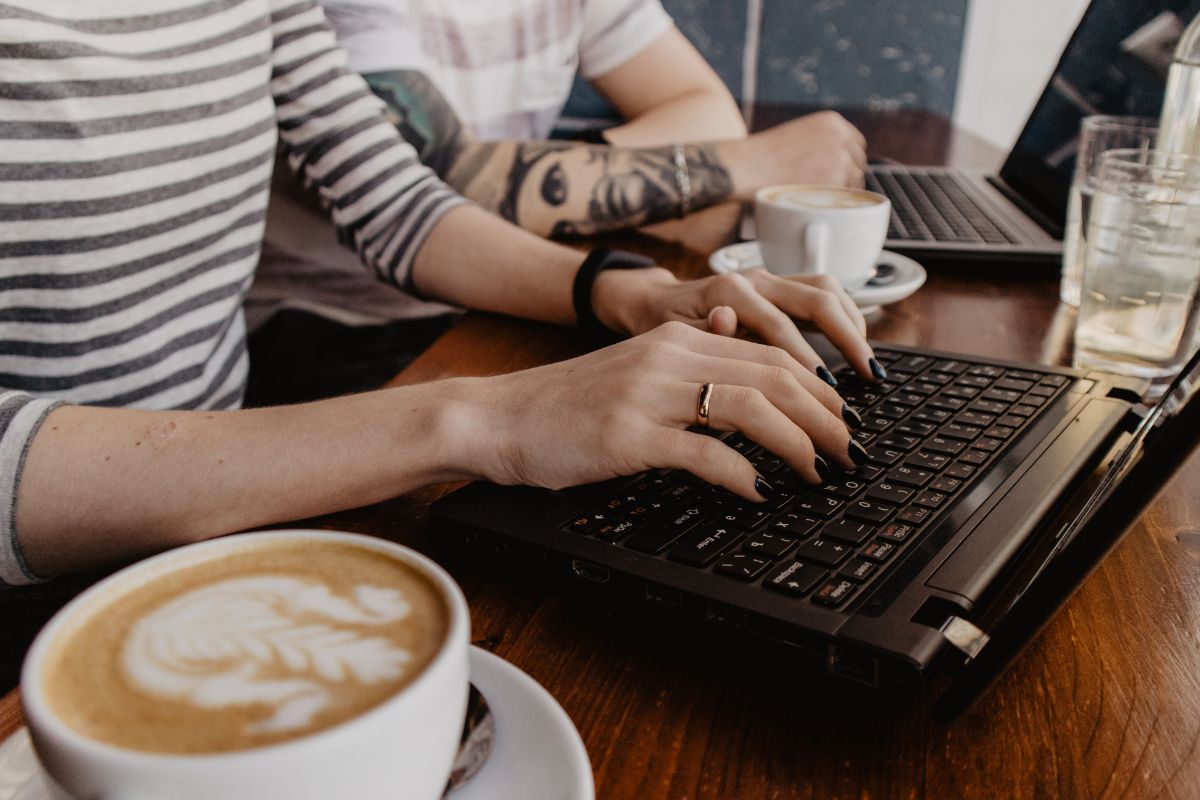 Image of a woman working while having a coffee.