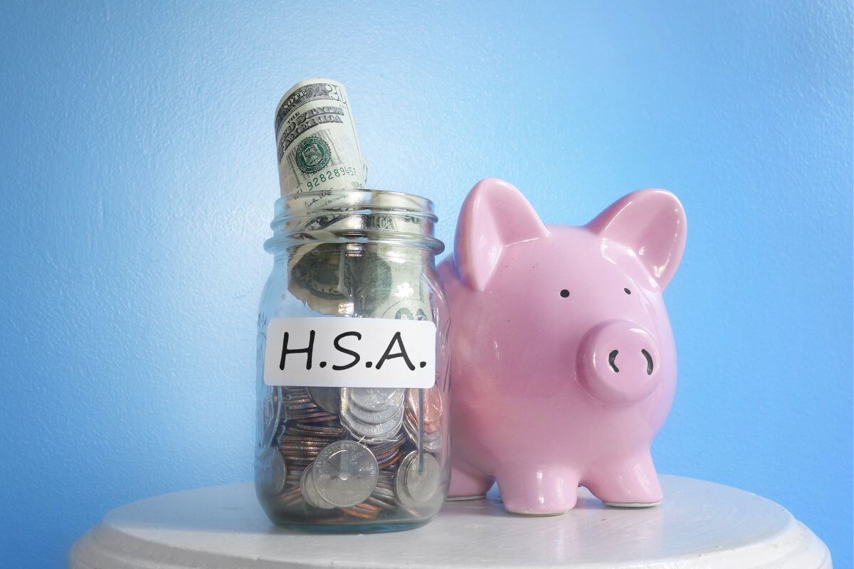 The image shows a piggy bank and a jar filled with coins, dollar bills, and a note referring to the use of HSA accounts for tax-free medical retirement funds can save you thousands later.