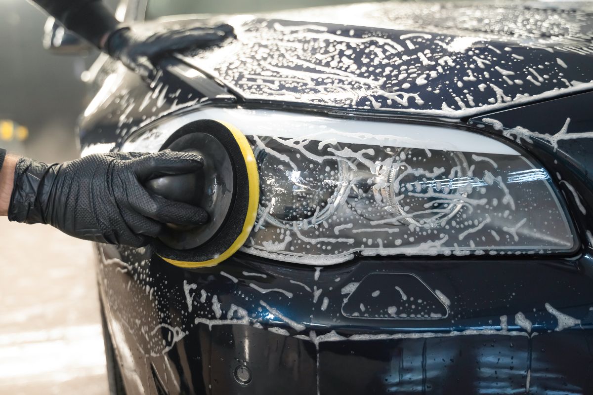 Image of a man's hand washing a car.